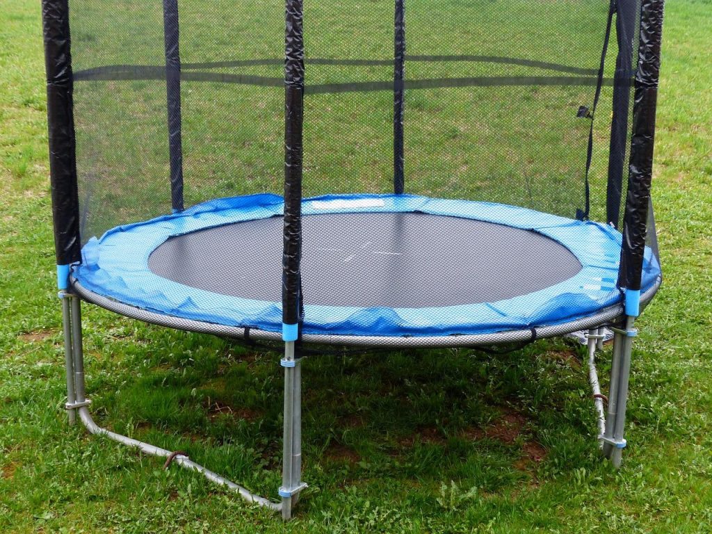 Kind springt op trampoline met plezier en demonstreert veilige sprongtechniek